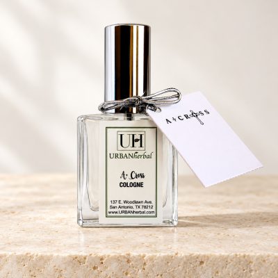 URBANherbal A+ Cross cologne with gift tag on warm ivory stone