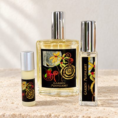 Garden Moonlight fragrance bottles and rollerball on warm ivory stone